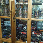 An antique cupboard filled with steins and antique toys
